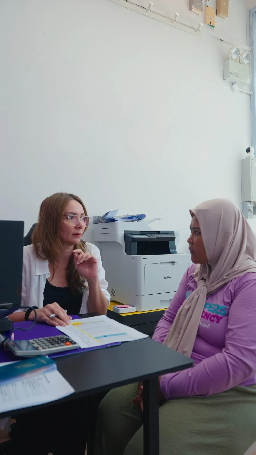 A Jaz Helpers consultant and a helper talking through placement paperwork at the office