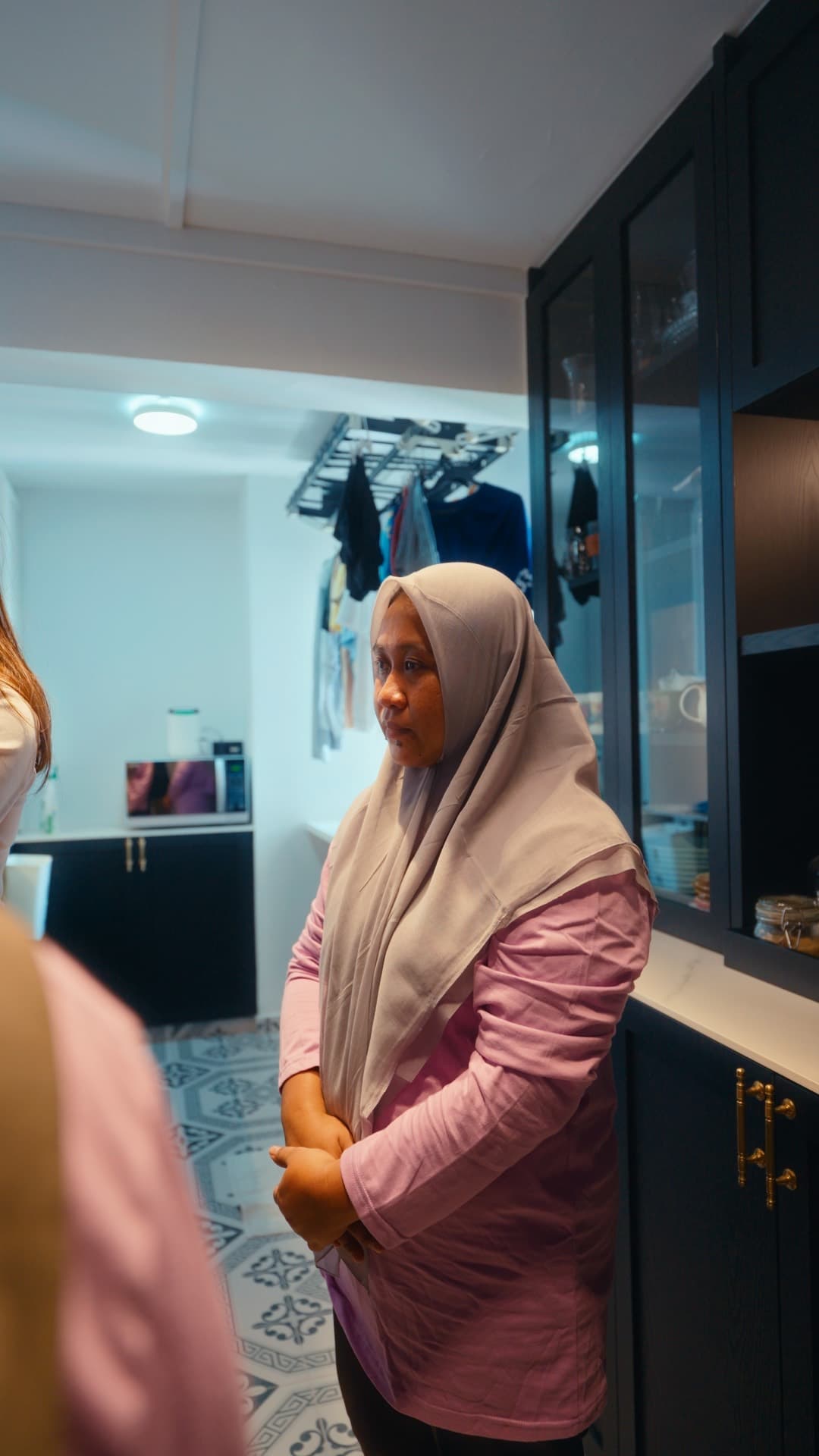 A domestic helper standing in the kitchen of a Singapore home