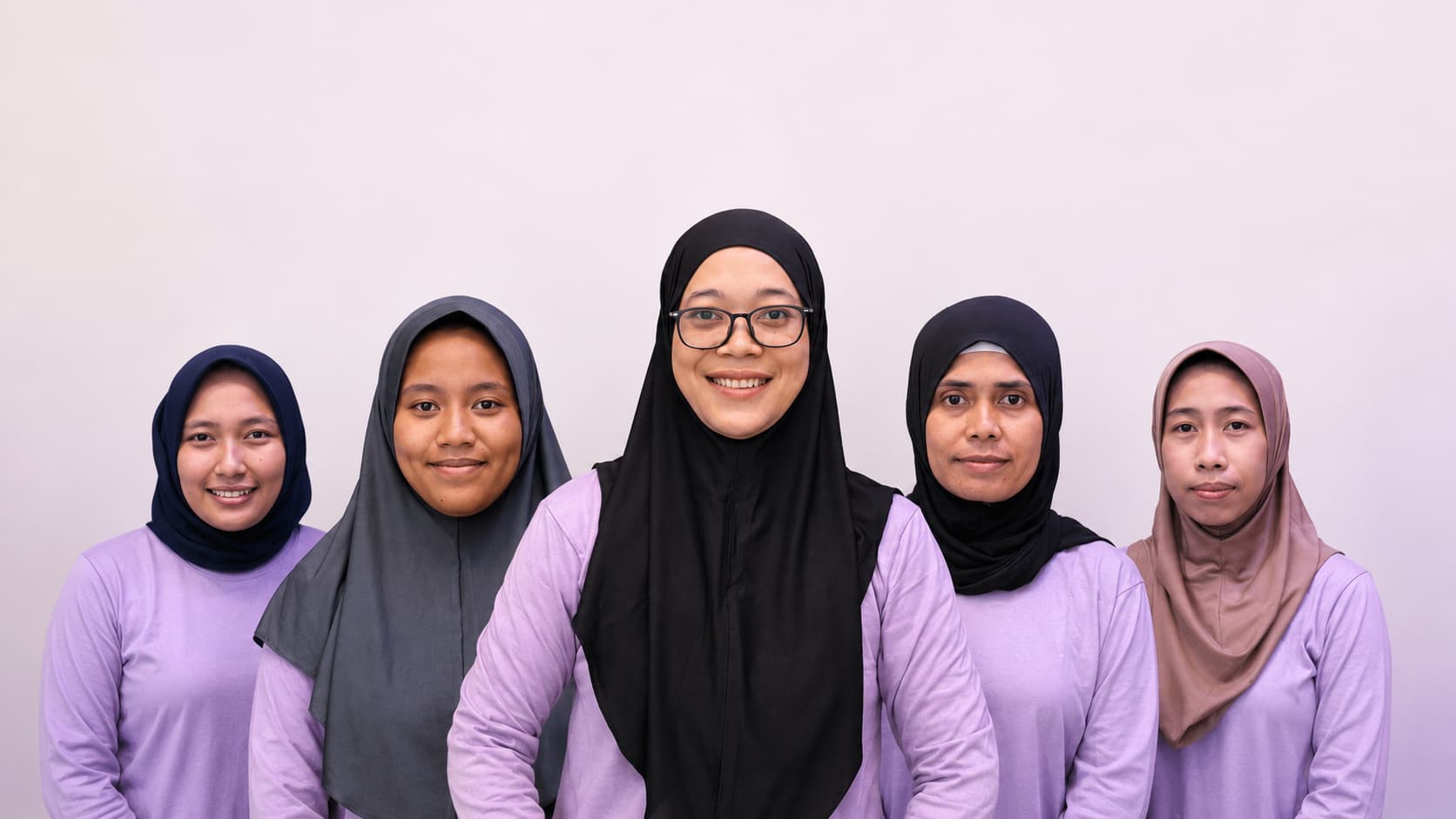 The Jaz Helpers team, five domestic helpers standing together and smiling